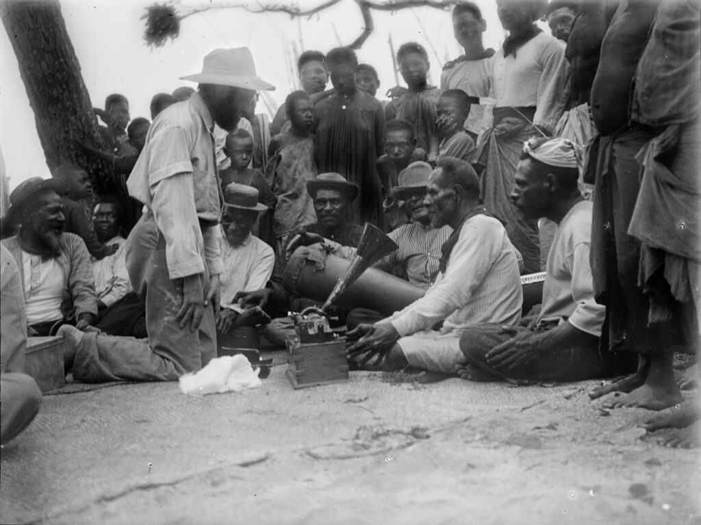 Charles Myers recording the sacred Malu songs. Ulai sings into the phonograph while Gasu plays the drum 'Wasikor'. Photo: Alfred Haddon, Mer, Torres Strait, 29 July 1898.